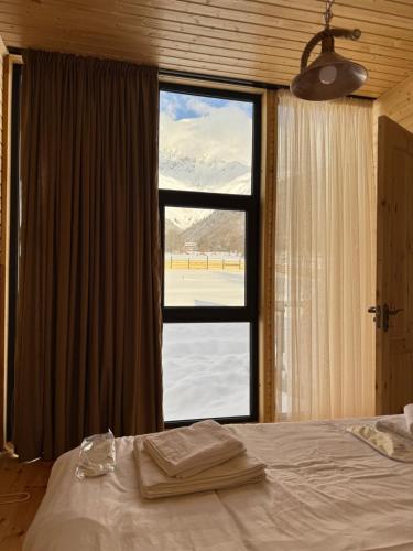 a bedroom with a bed and a large window at Panorama Mazeri in Tvebishi