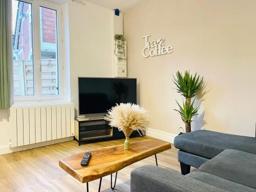 a living room with a tv and a coffee table at Chez le Padré in Olivet