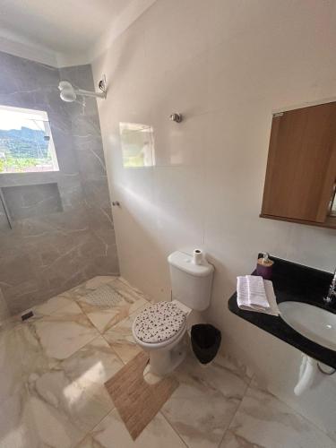 a bathroom with a toilet and a sink at CONDOMINIO JT ll in Ubatuba