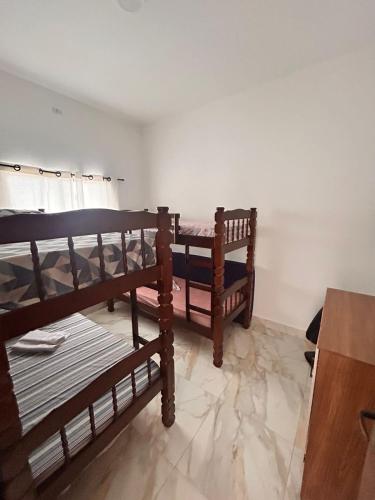 two bunk beds in a room with a table at CONDOMINIO JT ll in Ubatuba