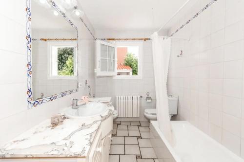 a white bathroom with a sink and a toilet at VILLA NUEVA II in Cala Galdana