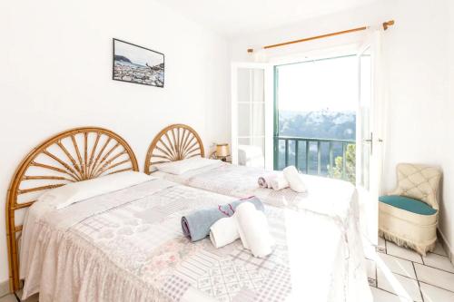 a bedroom with two beds and a balcony at VILLA NUEVA II in Cala Galdana