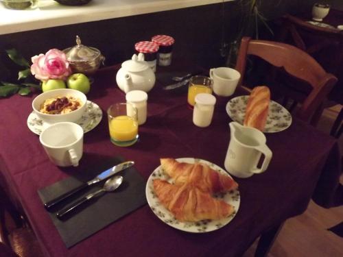 a table with plates of food and glasses of orange juice at Chambres De St Michel in Paimpol