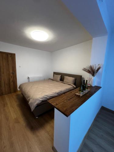 a bedroom with a bed with a wooden table at Apartament Atrium Gara Afi in Arad
