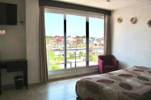 a bedroom with a bed and a large window at Hotel ESTRELLA in Zacatlán
