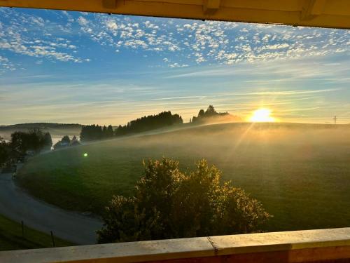 a misty sunrise with the sun rising over a field at Badischhaus am Waldrand & Weitblick in Herrischried