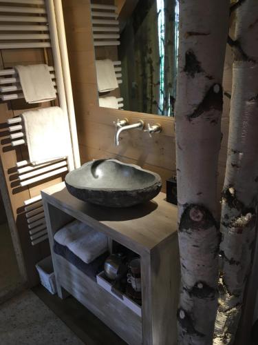 La salle de bains est pourvue d'un lavabo sur un plan de travail avec un arbre. dans l'établissement Chalet Mine de rien, à Megève