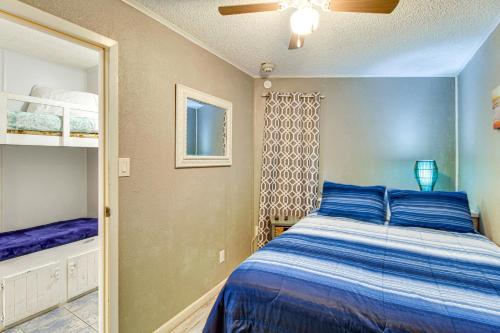 a bedroom with a blue bed and a mirror at Steps to North Beach: Gem w/ Ocean-View Balcony! in Corpus Christi