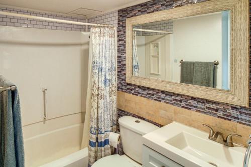 a bathroom with a toilet and a sink and a mirror at Steps to North Beach: Gem w/ Ocean-View Balcony! in Corpus Christi