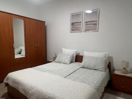 a bedroom with a bed and a cabinet and a mirror at Apartment Vesna in Veleniki