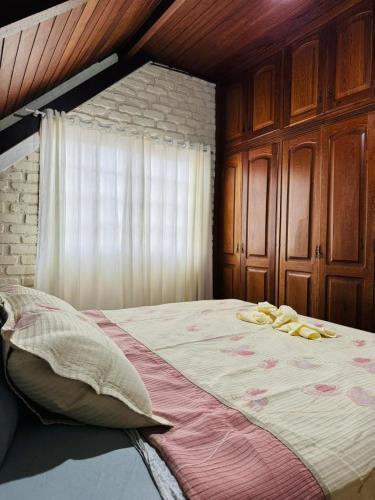 a bedroom with a large bed and a window at Deruci Chale in Nova Friburgo