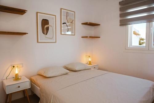 a bedroom with a white bed and two night stands at Aelia Kastraki Beach House in Kastraki