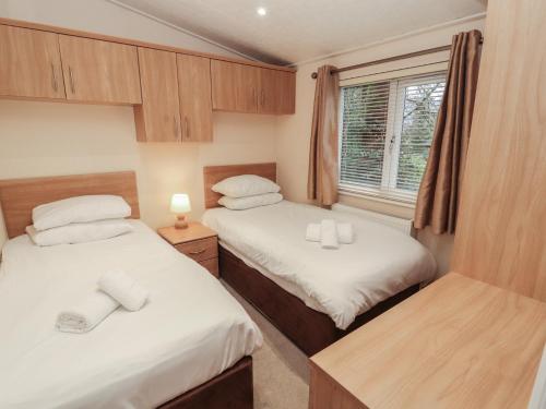 two beds in a small room with a window at Beech Hill Lodge Beech Hill 9 at Fallbarrow Park in Windermere