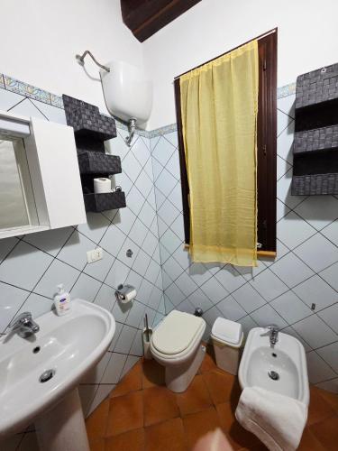 a white bathroom with a sink and a toilet at Casa Alba Marina in Marzamemi