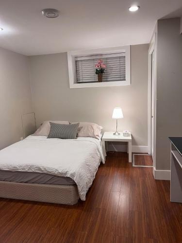 a bedroom with a bed and a table and a window at Vancouver Comfort Home 10 min to YVR airport, Close to Downtown in Vancouver