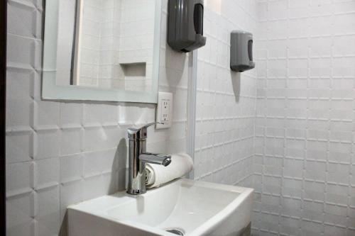 a white bathroom with a sink and a mirror at Hotel ESTRELLA in Zacatlán