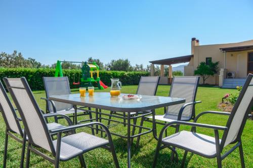 a table and chairs on a lawn with orange juice at Naxos Cottage in Káto Sangríon