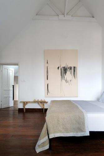 une chambre avec un lit et un tableau au mur dans l'établissement Hakanto House, à Antananarivo