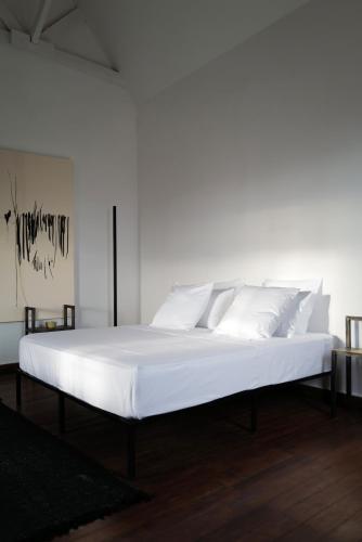 un grand lit blanc avec des oreillers blancs dessus dans l'établissement Hakanto House, à Antananarivo