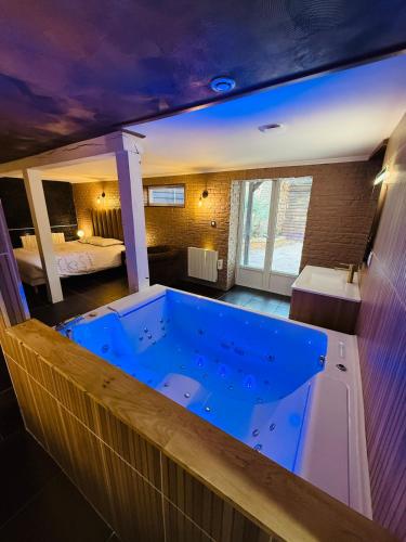 a large blue tub in a room with a bedroom at Le Cupidon & Spa in Pont-Sainte-Maxence