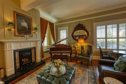 a living room with a fireplace and a piano at The Allen House in Ridgefield