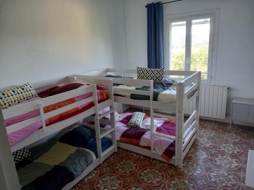 two bunk beds in a room with a window at La maison in Cruviers-Lascours