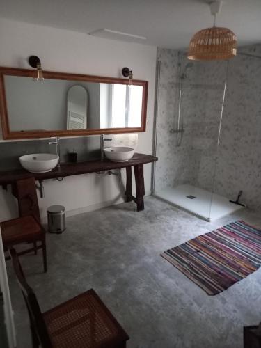 a bathroom with two sinks and a mirror at La maison in Cruviers-Lascours