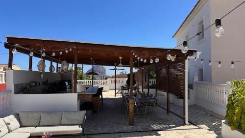 a pergola on a patio with a couch and a table at Casa Amis Calpe in Calpe