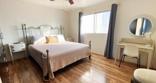 a bedroom with a bed and a desk and a mirror at Tu Casa de Familia in Tijuana