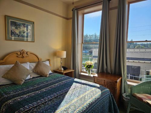 a bedroom with a bed and a large window at Hotel Planter in La Conner