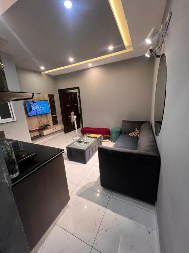 a living room with a couch and a tv at HNC Arcade in Dargai