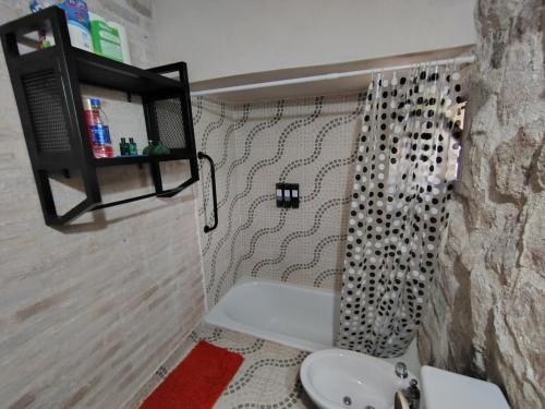 a bathroom with a sink and a shower curtain at Stone Cabin, PETRA HAUS in Cuesta Blanca