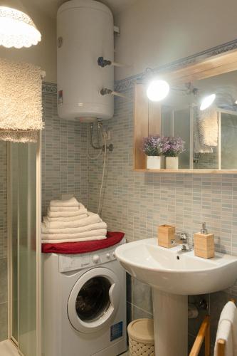 a bathroom with a washing machine and a sink at Prali Ski House - 4beds - Parking - Garden in Prali