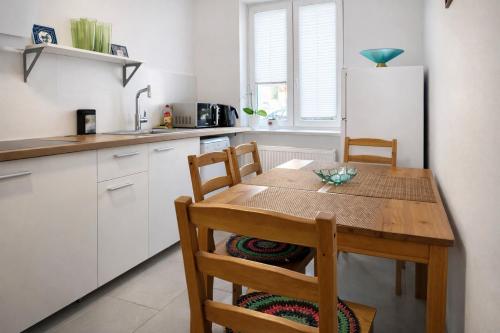 a kitchen with a wooden table and a refrigerator at FRAME by Tendo Stay - Comfort Housing in Falkensee