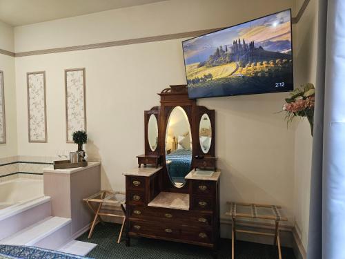 a bathroom with a vanity and a tv on the wall at Hotel Planter in La Conner