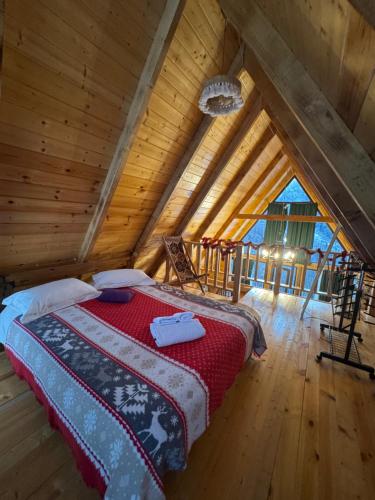 a bedroom with a bed in a wooden attic at Villa Cottage Merisi in Inasharidzeebi