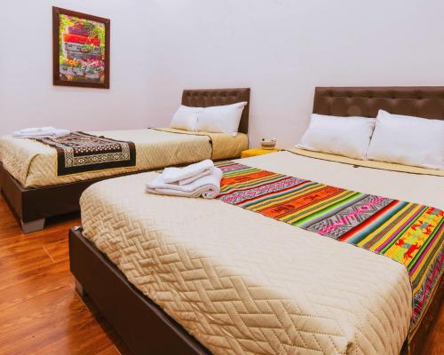 two beds sitting next to each other in a room at Hotel Casa Santiago in Pasto