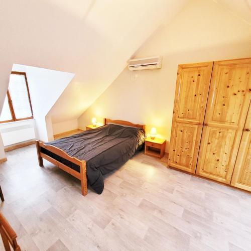 a bedroom with a bed and some wooden cabinets at Gite De l'Augereau in Céré-la-Ronde