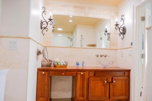 a bathroom with a wooden vanity and a mirror at Beach Escape, King Suite, Ocean Views, Pet Friendly in Destin