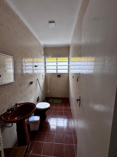 a bathroom with a sink and a toilet at Casa de praia in Mongaguá