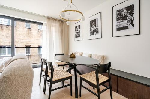 a dining room with a table and chairs and a couch at Casa Blanc - Coastal Triplex in Blankenberge