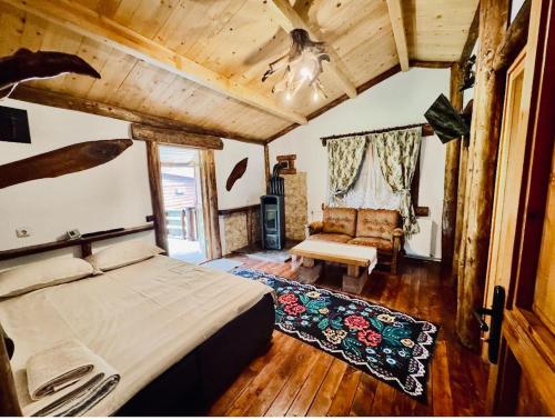 a bedroom with a bed and a couch in a room at Cabana MARISA in Dărmăneşti