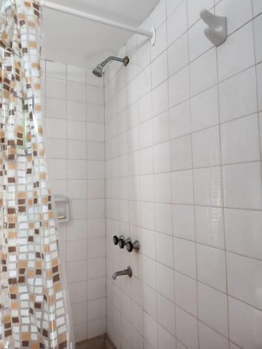 a bathroom with a shower with white tiles at Casa Centrica 5 Huésped in Pinamar
