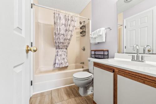 a white bathroom with a toilet and a sink at Baytree 28G in Little River