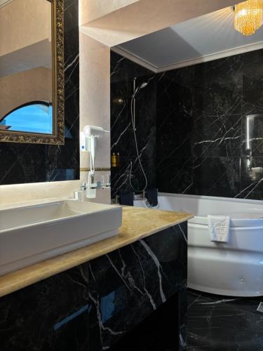 a bathroom with a sink and a toilet at Cardinale Resort in Iaşi