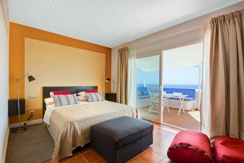 a bedroom with a bed and a view of the ocean at Can Panorama in Talamanca