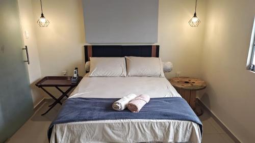 a bedroom with a bed with two towels on it at Boulevard Amazon Suites in Manaus