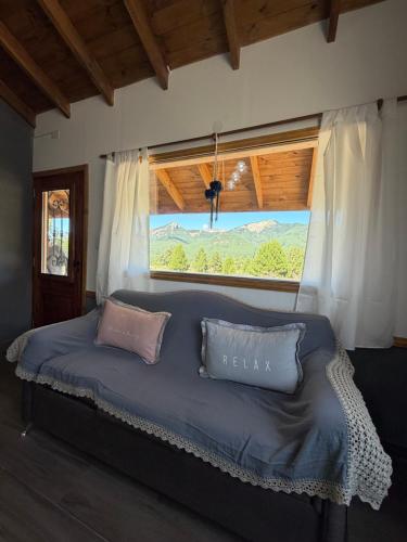 a bed with two pillows in a room with a window at Betsaida2 in Lago Meliquina