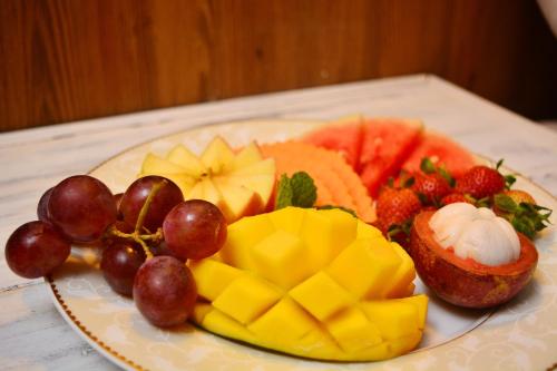 Un plato de comida con fruta en una mesa. en Unique Cottages, en Nuwara Eliya