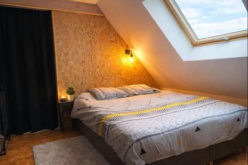a bedroom with a large bed with a skylight at le Sunset Loft 88 maison neuve et moderne in Sainte-Adresse